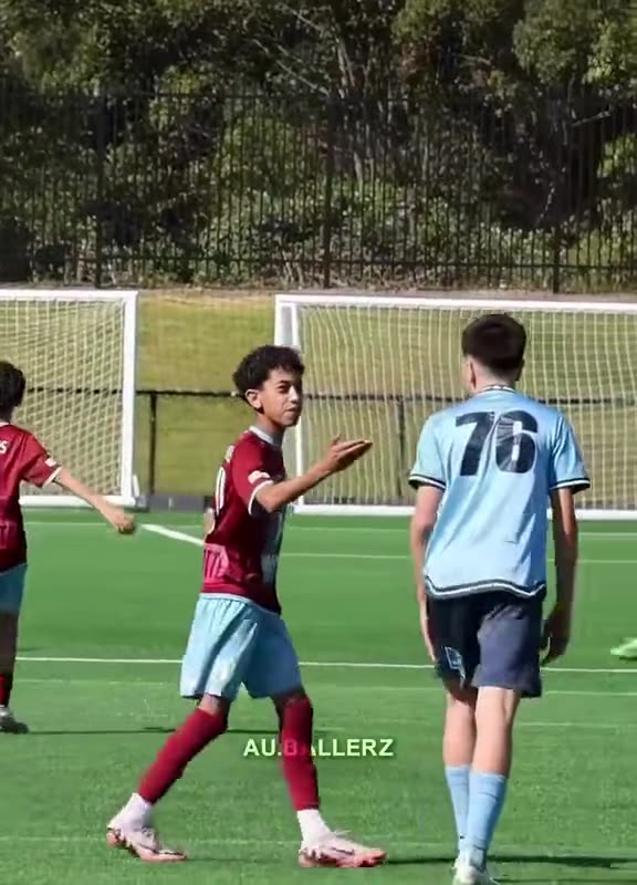 Young winger in maroon shapes to beat a defender wearing number 76