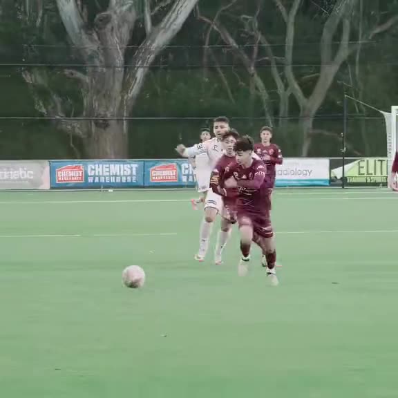 Academy player in white drives forward with the ball